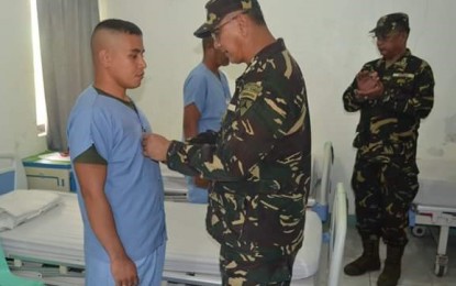 <p><strong>MEDALS FOR THE WOUNDED.</strong> Brigadier General Dinoh Dolina, commander of the Army’s 3<sup>rd</sup> Division, awards the Wounded Personnel Medal to one of the 62<sup>nd</sup> Battalion soldiers injured in a clash with communist rebels in Kabankalan City, Negros Occidental last May 12. Awarding was held at the Camp Peralta Station Hospital in Jamindan, Capiz on Tuesday (May 15,2018). <em>(Photo courtesy of Philippine Army, 3<sup>rd</sup> Infantry Division)</em></p>
<p> </p>
<p> </p>